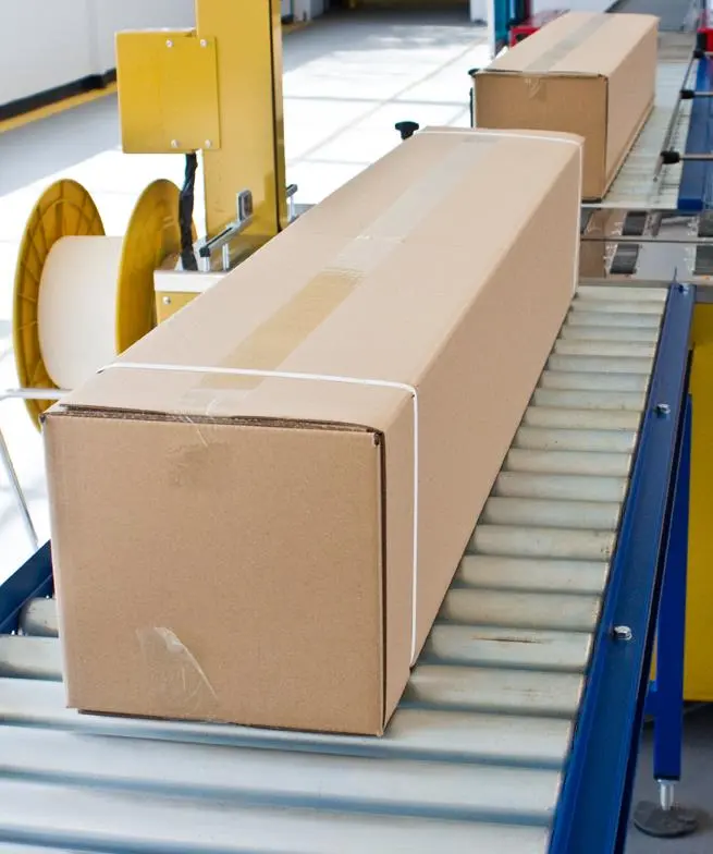 Cajas en linea de producción con zuncho PP Tewe A blanco.webp